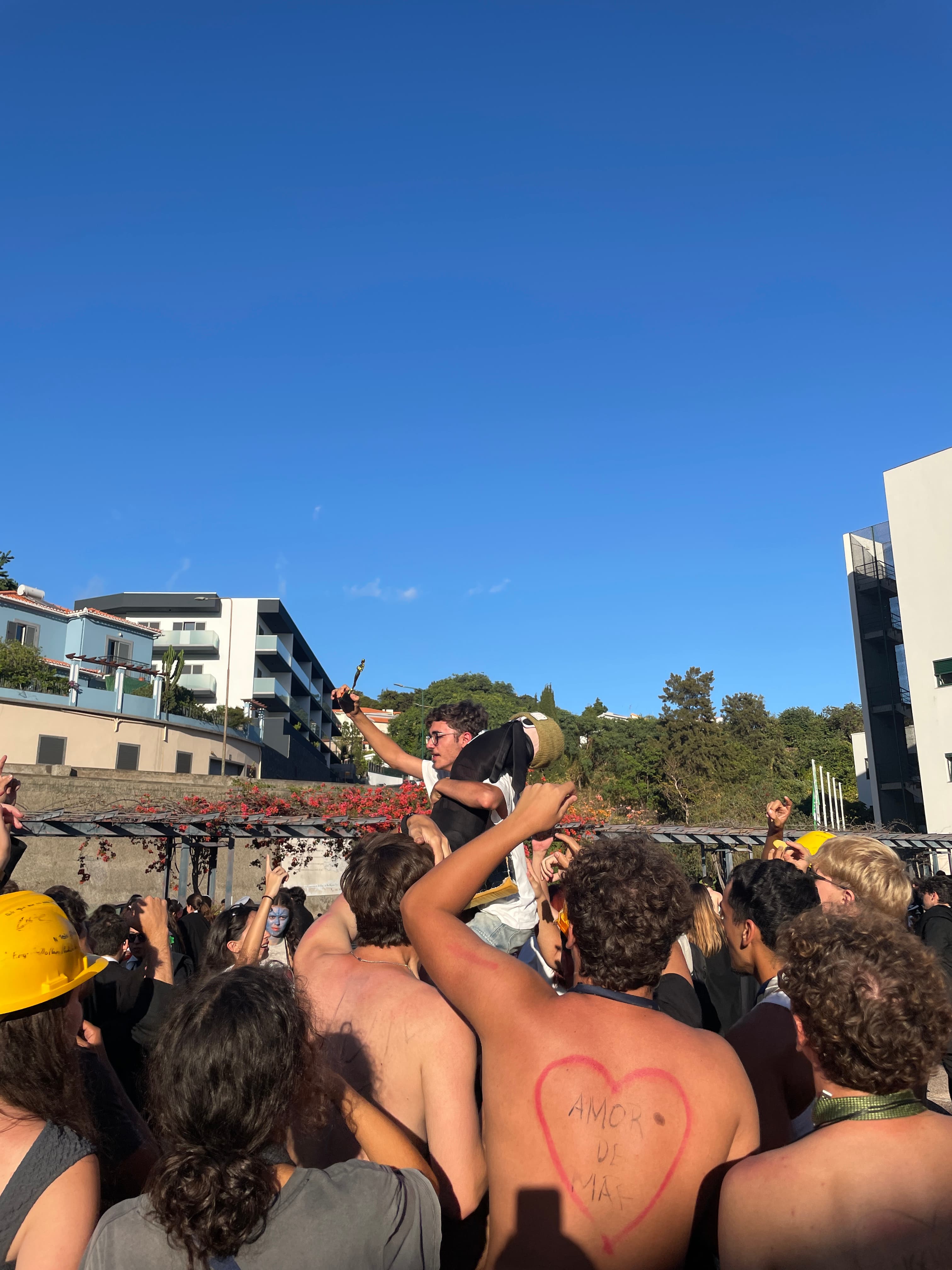 Um estudante é erguido pelos colegas durante um encontro no campus.