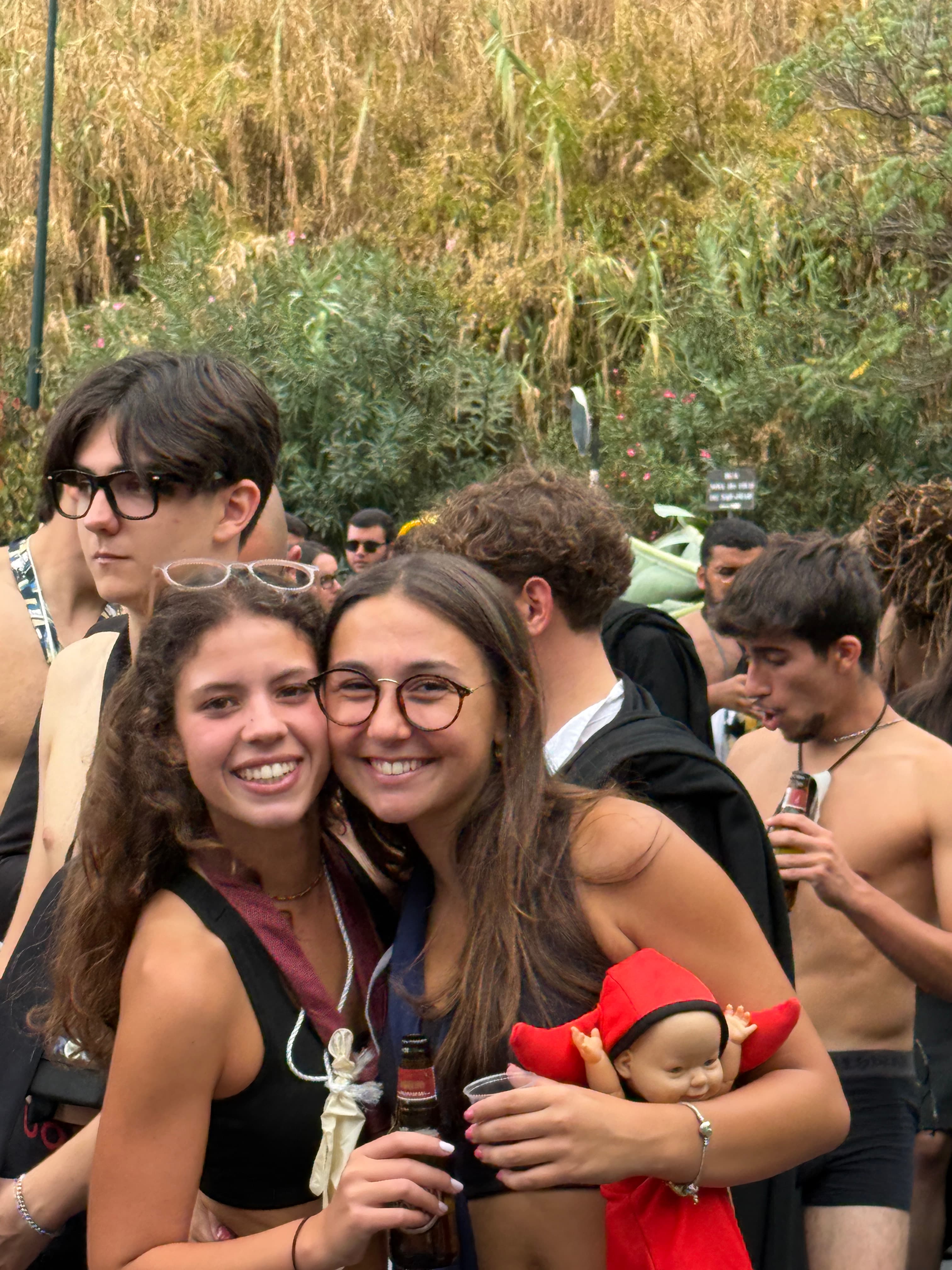 Duas estudantes abraçadas sorriem para a fotografia durante um convívio ao ar livre.